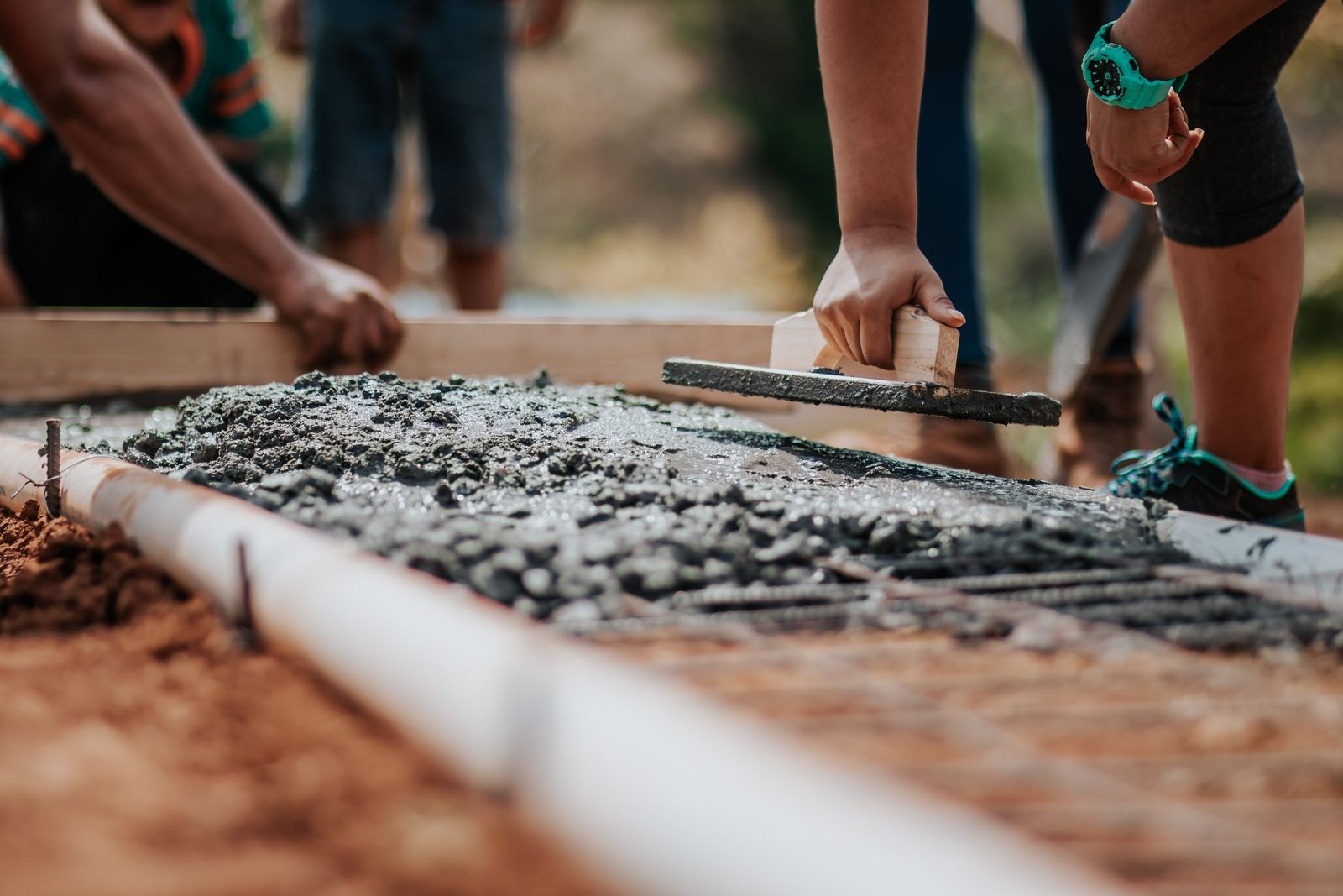 Wet concrete finishing on a slab — field still, illustrative of the work.