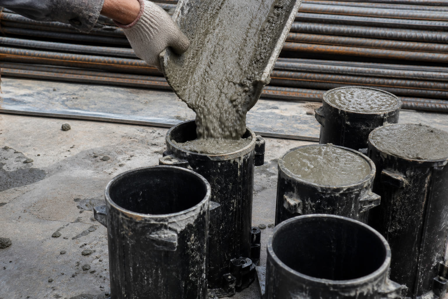 Concrete test cylinders on a jobsite — field still, illustrative of the work.